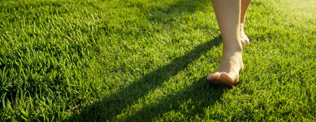 A woman walking barefoot in grass