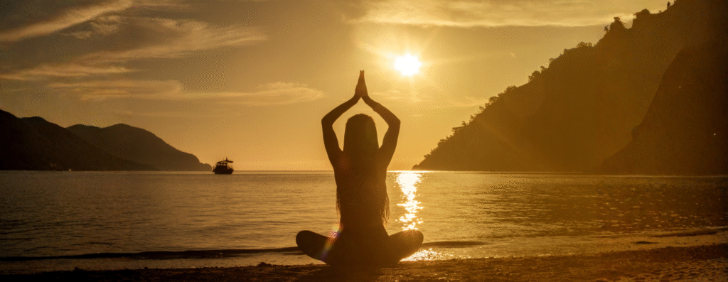 a woman meditating by the ocean